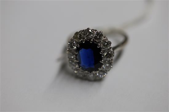 A modern white gold?, sapphire and diamond set oval cluster ring, size N.